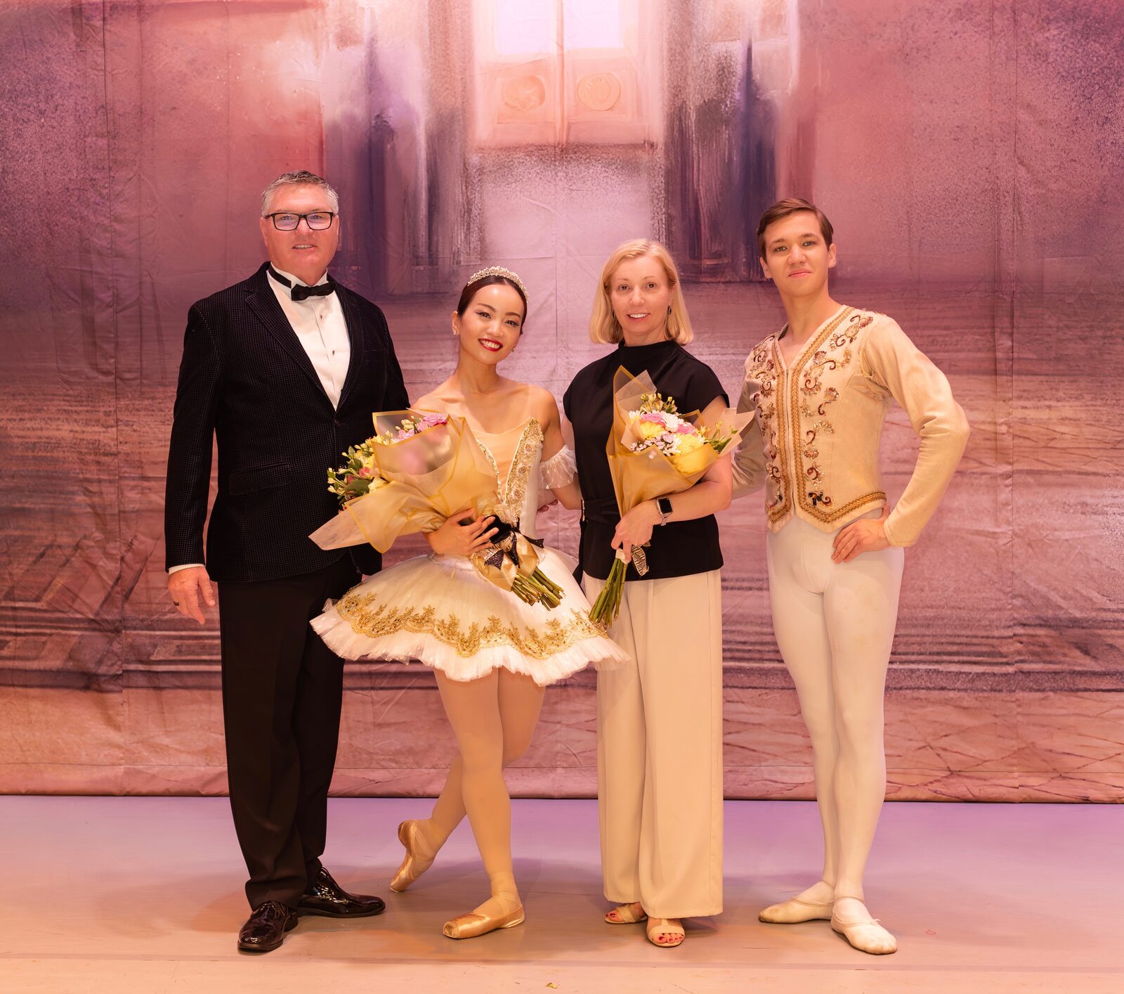 Brevard Ballet Academy directors with dancers in gold costumes on stage after a performance