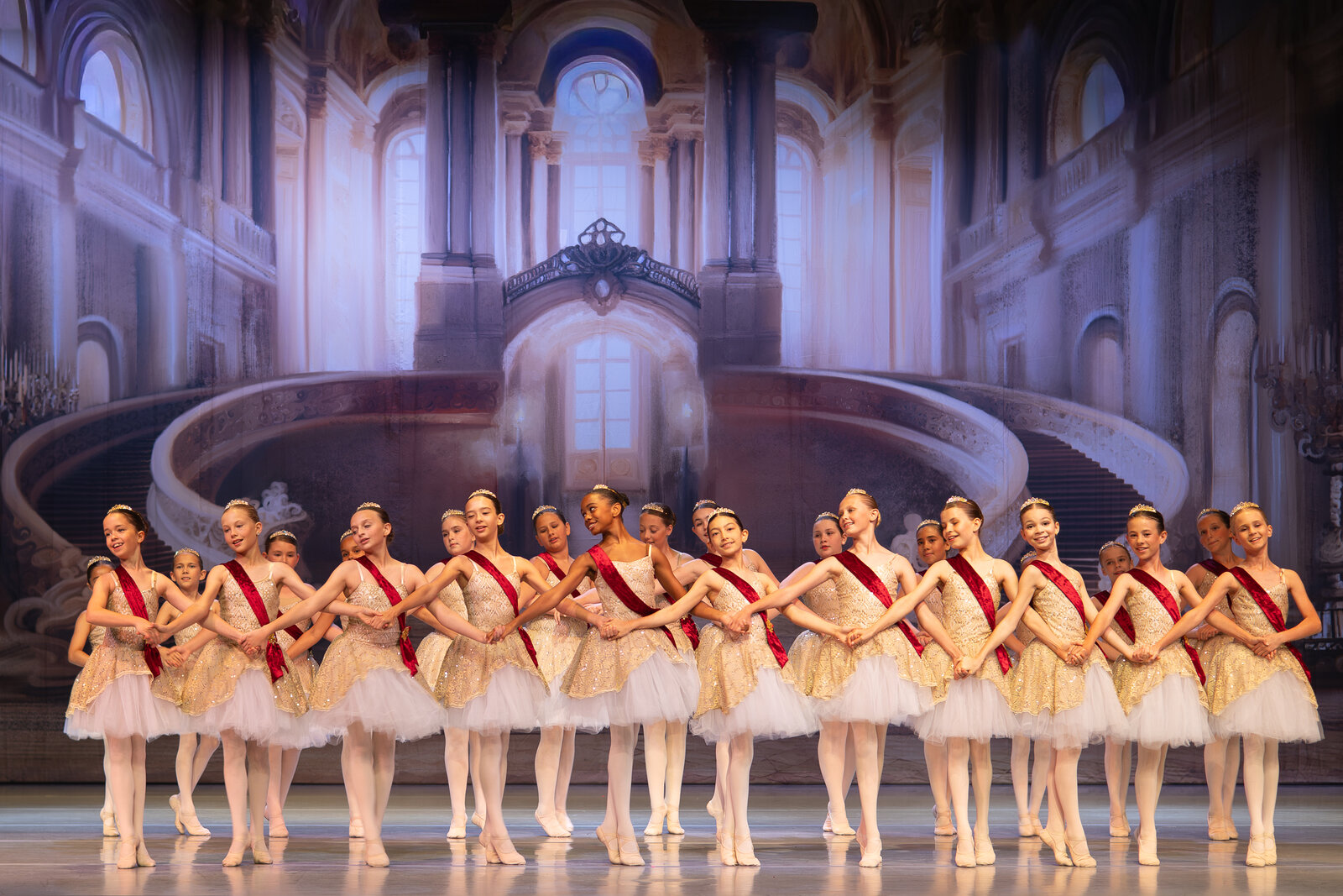 Brevard Ballet Youth Company dancers in gold tutus and red sashes on stage in Melbourne FL